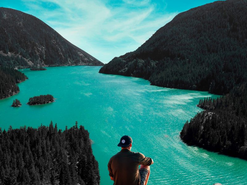 Canva-Man-Sitting-on-Cliff-in-Front-of-Body-of-Water-1-1